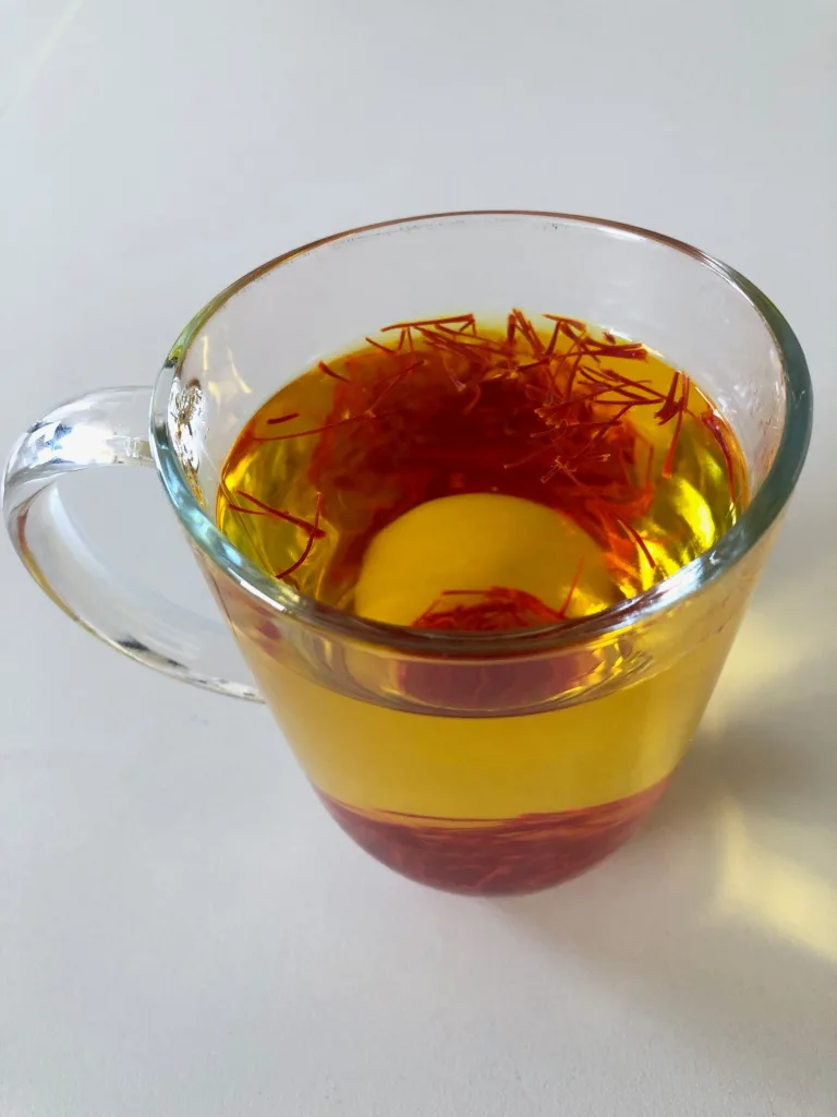 Golden cup of saffron tea with visible saffron threads