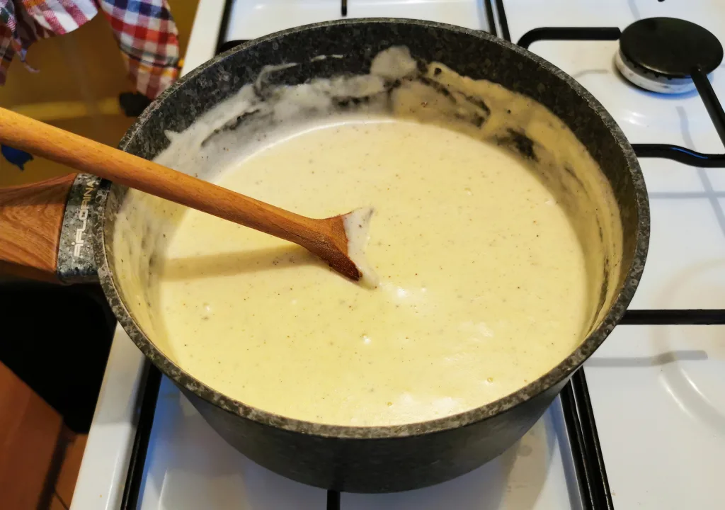 Golden cream sauce simmering gently in a saucepan